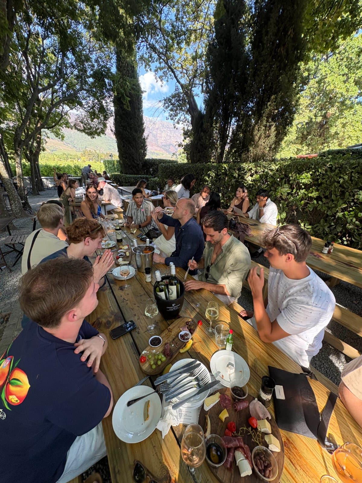 A long table of founders under the trees